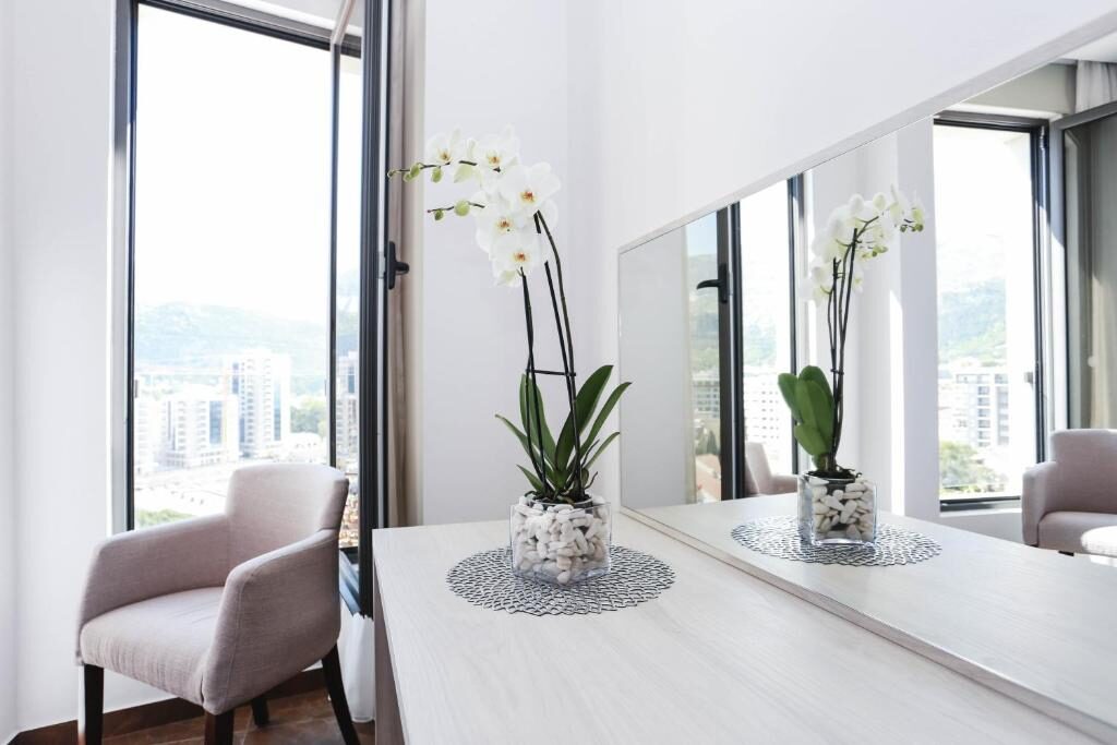 Interior detail with orchid, mirror and view towards the hills of Budva